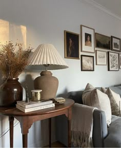 a living room filled with furniture and framed pictures on the wall above a coffee table