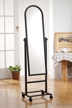 a large mirror is sitting on top of a black stand in the middle of a room