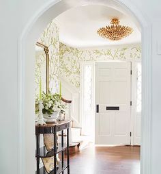 an entry way with a table, mirror and vases on the end tables in front of it