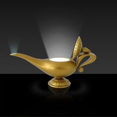 a golden bird shaped vase with a light shining on it's head and wings