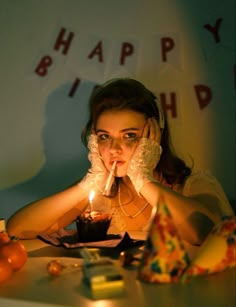 a woman sitting at a table with a candle in her mouth