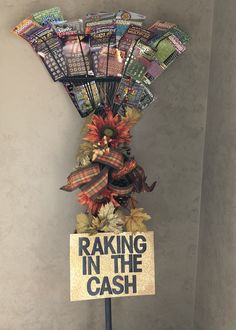 a sign that says raking in the cash on top of a stand with fake flowers