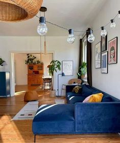 a living room filled with furniture and lots of lights hanging from the ceiling above it