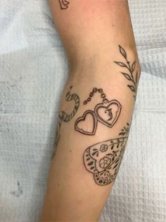 a woman's arm with tattoos on it, including two heart shaped lockes