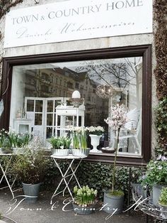 a window display with potted plants in front of it and the words town & country home