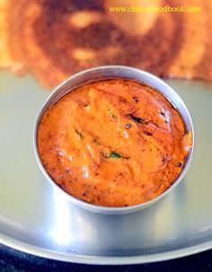 there is a small bowl of food on the plate next to some grilled bread