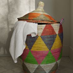 a colorful basket with a white towel on top