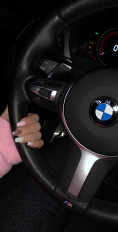 a woman driving a car with her hand on the steering wheel and holding onto the dashboard