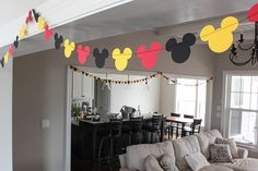 a living room filled with furniture and a mickey mouse banner on the wall above it