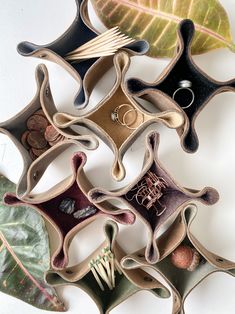 a group of rings sitting on top of different shapes and sizes of leaf shaped objects