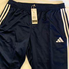 Blue Adidas Comfortable Athletic Pants With Zippers On Pockets And Lower Legs. Blue Wide Leg Joggers With Pockets, Blue Wide-leg Joggers With Pockets, Adidas Blue Joggers For Sports, Blue Athleisure Sweatpants With Three Stripes, Adidas Blue Sports Bottoms, Adidas Blue Sporty Joggers, Navy Sports Bottoms With Three Stripes, Adidas Full Length Athleisure Bottoms, Adidas Athleisure Pants With Elastic Waistband