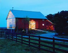 a red barn lit up at night in the country