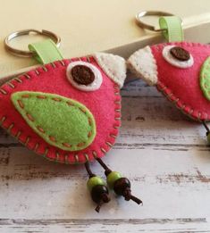 two pink and green bird shaped key chains