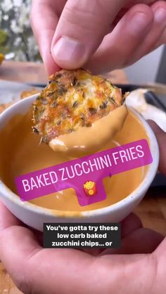 someone is dipping some kind of food in a bowl with the words baked zucchini fries on it