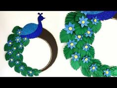 two paper wreaths decorated with blue flowers and green leaves, one in the shape of a peacock