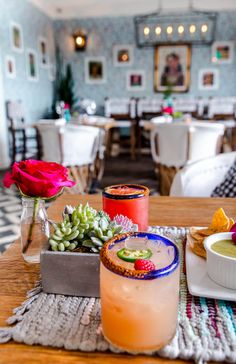 a table topped with drinks and plates filled with food