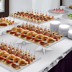 a table topped with lots of different types of sandwiches and cupcakes on top of plates