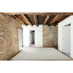 an empty room with stone walls and wooden beams