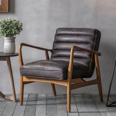 a chair sitting next to a table with a potted plant on it