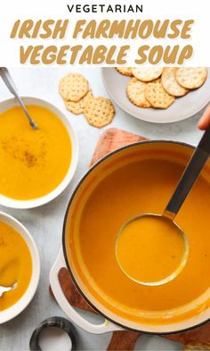 a bowl of carrot soup with crackers on the side and a spoon in it