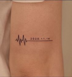 a woman's arm with a heartbeat tattoo on the left side of her body