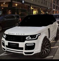 a white range rover parked on the side of a street