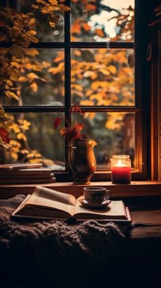 an open book and candle on a window sill