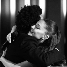 two women hugging each other in black and white