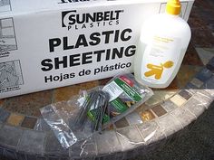 the plastic sheeting is sitting on the table next to the box and other items