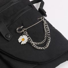 a black backpack with a daisy charm attached to it