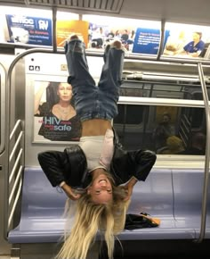 a woman is upside down on the subway