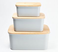 three ceramic containers stacked on top of each other with wooden lids and wood rims