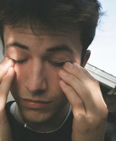 a man holding his hands to his eye