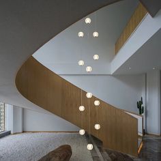 a modern staircase with lights hanging from it's sides and wood handrails