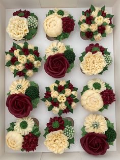 cupcakes decorated with flowers and leaves in a box