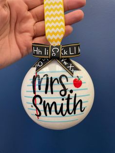 a hand holding a christmas ornament with the words mrs smith on it