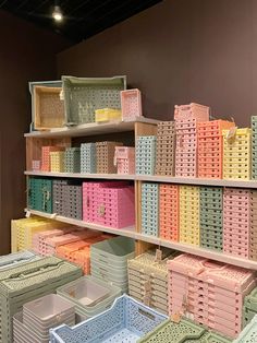 the shelves are filled with many different colored boxes and baskets, all stacked on top of each other