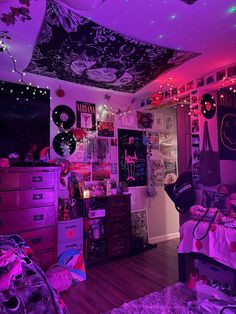 a bedroom with purple lighting and decorations on the ceiling, bedding and dressers