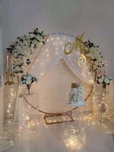 a white wedding cake sitting on top of a table next to some candles and flowers