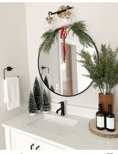 a bathroom sink with a mirror above it and a bottle of wine on the counter