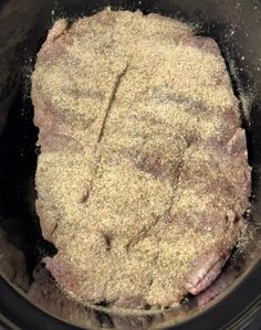 the meat is being cooked in the crockpot with seasoning on top and ground