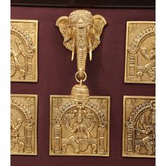 four golden wall hangings with an elephant head on one side and two smaller ones on the other