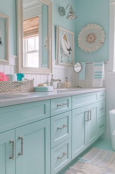 a bathroom with blue walls and white fixtures, including a large mirror above the sink