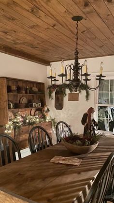 a dining room table and chairs in front of a window with christmas decorations on the windowsill