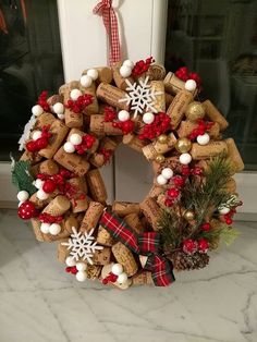 a wreath made out of wine corks and christmas decorations