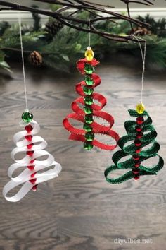 three christmas ornaments hanging from a tree branch