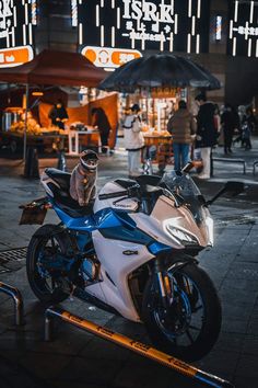 a white and blue motorcycle parked in front of a building