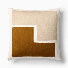 a brown and white pillow with square shapes on the front, along with an orange border