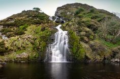 a small waterfall in the middle of a body of water