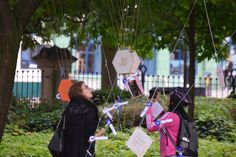 two women looking up at signs hanging from the trees